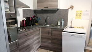 A compact kitchen with a dishwasher, a coffee maker, and a sink. - ENTRE MER ET FORET" vacation home (Le Tréport)
