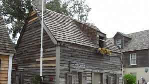 Un bâtiment en bois sur lequel est apposée une plaque indiquant qu’il s’agit du plus ancien bâtiment scolaire des États-Unis.