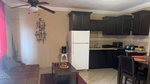 A compact living space with a kitchenette, a dining area, and a seating area.