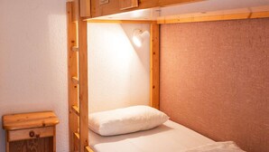 A bunk bed with a wooden headboard and a small wooden nightstand. - Val Thorens - Cozy apartment for 4, ski-in/ski-out, elevator (Val Thorens)