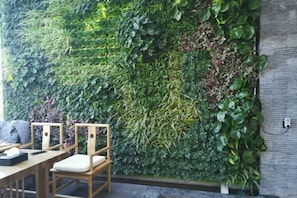 A wall with a vertical garden, wooden chairs, and a table. - Manyuegu Smart Choice (Xiangyun)