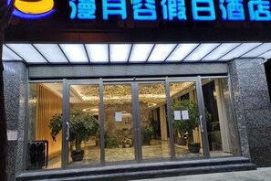 A hotel entrance with a glass door and a sign above it.