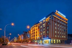 A multi-story hotel with illuminated signage and a well-lit facade.