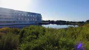 Un hotel moderno con diversi piani e un riflesso nell'acqua.