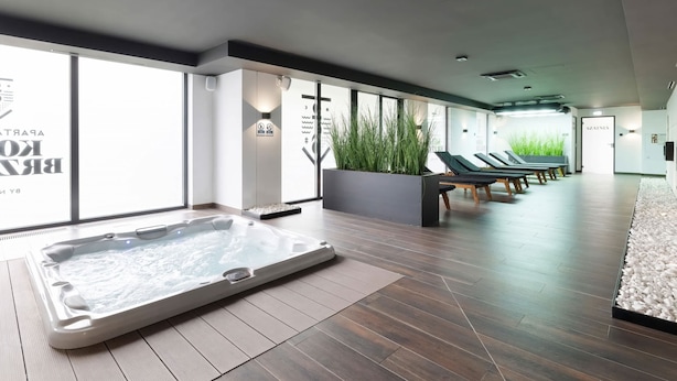 Un área de spa moderna con hidromasaje, sillones reclinables y ventanas amplias.