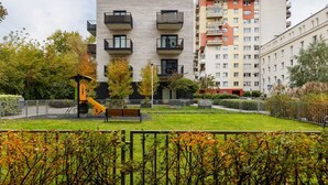 Un immeuble résidentiel doté de balcons, d’une aire de jeux et d’un jardin clos.