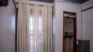 Ein Zimmer mit Schiebetür, einer Mikrowelle und einem kleinen Schrank.