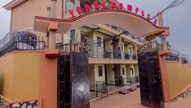 A building with a sign reading "YOBOS COMPLIA" and a gated entrance.