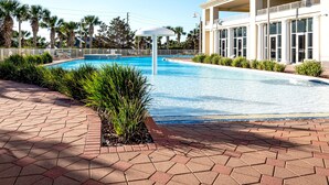 A swimming pool with a white canopy, surrounded by a brick walkway and palm trees. - Ariel Dunes I 1207 Beach Access*3 pools* (Miramar Beach)