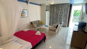 Ein Hotelzimmer mit Bett, Schreibtisch, Stuhl und einem Balkon mit Aussicht.