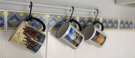 Kitchen utensils hanging on a rack with a tiled backsplash.