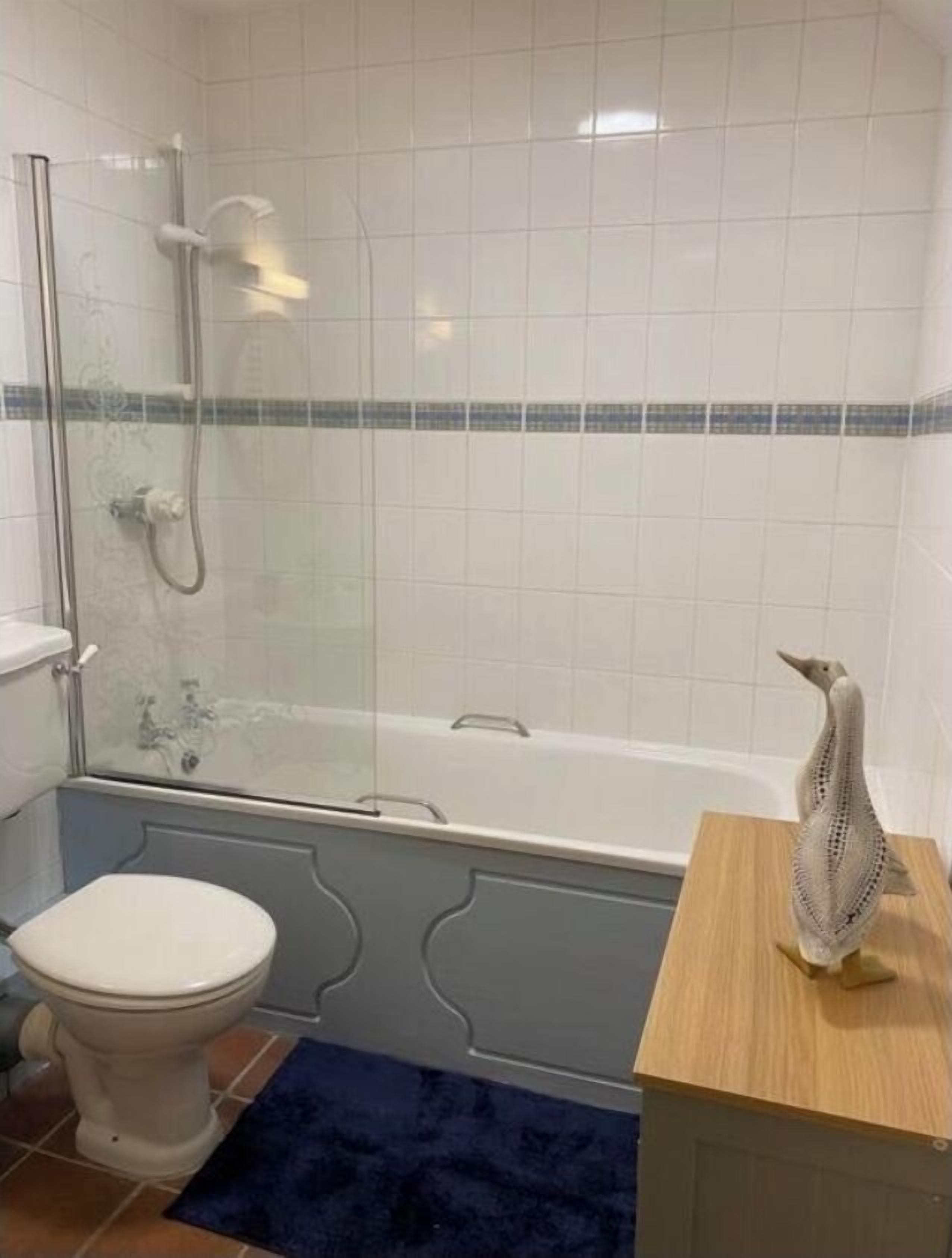 Ein Badezimmer mit Duschkabine, Toilette und Badewanne.