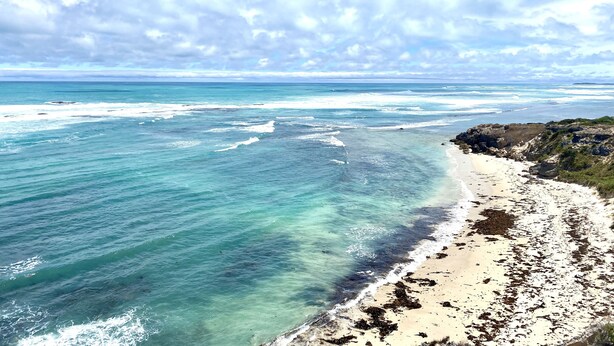 A coastal landscape with clear turquoise waters, a sandy beach, and rocky outcrops. - Ongermein, double story beach house a stone throw from the Indian Ocean.  (Port Macdonnell)