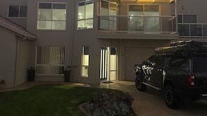 A two-story house with a garage, a car parked in the driveway, and a well-maintained lawn. - Ongermein, double story beach house a stone throw from the Indian Ocean.  (Port Macdonnell)