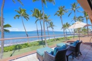 A balcony with wicker furniture, a view of the ocean, and palm trees. - Spectacular, Oceanfront 3 bedroom + den, AC, pool, sleeps 7. (Lahaina)