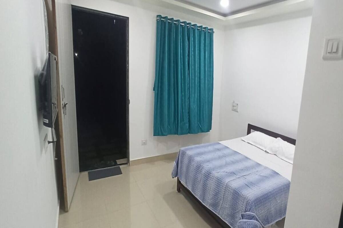 A bedroom with a bed, a wardrobe, and a curtain.