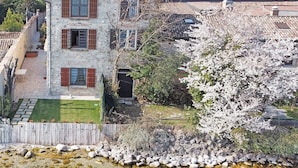 A stone house with a garden and a pond. - Villa "L'antica Lugana" with lake view, balconies, and Wi-Fi (Sirmione)