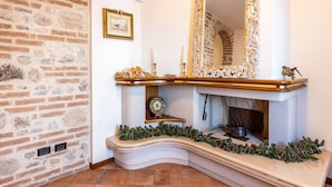 A fireplace with a mantel, a mirror, and a framed picture on the wall. - Villa "L'antica Lugana" with lake view, balconies, and Wi-Fi (Sirmione)
