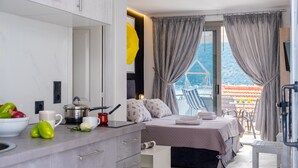 A modern hotel room with a bed, a small kitchen area, a balcony with a view, and a dining area. - Studio Apartment 'Chakalaka with Sofa Bed 15' with Sea View, Wi-Fi and Air Conditioning (Leykada)