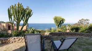 Two lounge chairs facing a coastal view with cacti and a stone wall. - Villa "Water Front Scopello" with Sea View, Private Beach Access, Garden, and Wi-Fi (Scopello)