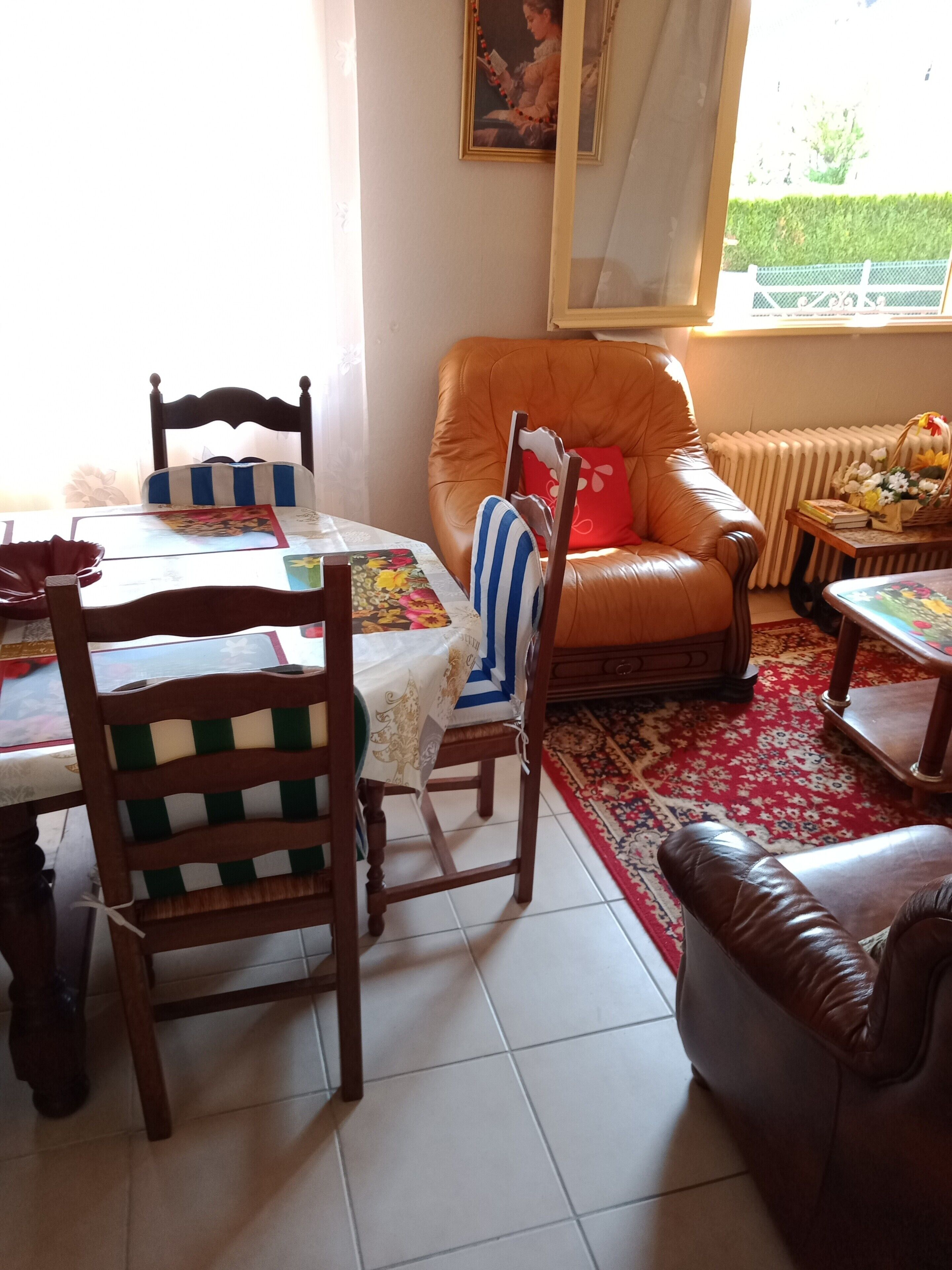 Ein Essbereich mit Tisch, Stühlen, einer Couch und einer Heizung.