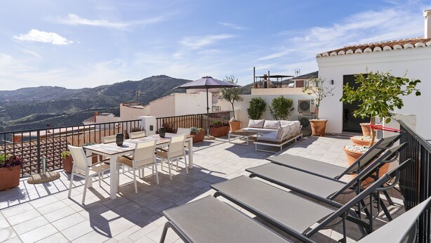 A terrace with outdoor furniture, potted plants, and a view of the hills. - Holiday Home "El Cine" with Mountain View, Pool & Wi-Fi (Canillas de Albaida)