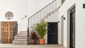 A poolside area with a staircase, a wooden door, and potted plants. - Holiday Home "El Cine" with Mountain View, Pool & Wi-Fi (Canillas de Albaida)