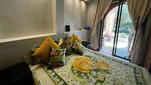 Camera d'albergo con un letto, un tavolino, una sedia e vista sull'esterno.