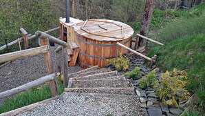 Una sauna de fusta amb un sostre circular, envoltada per una tanca de fusta i un camí de grava.