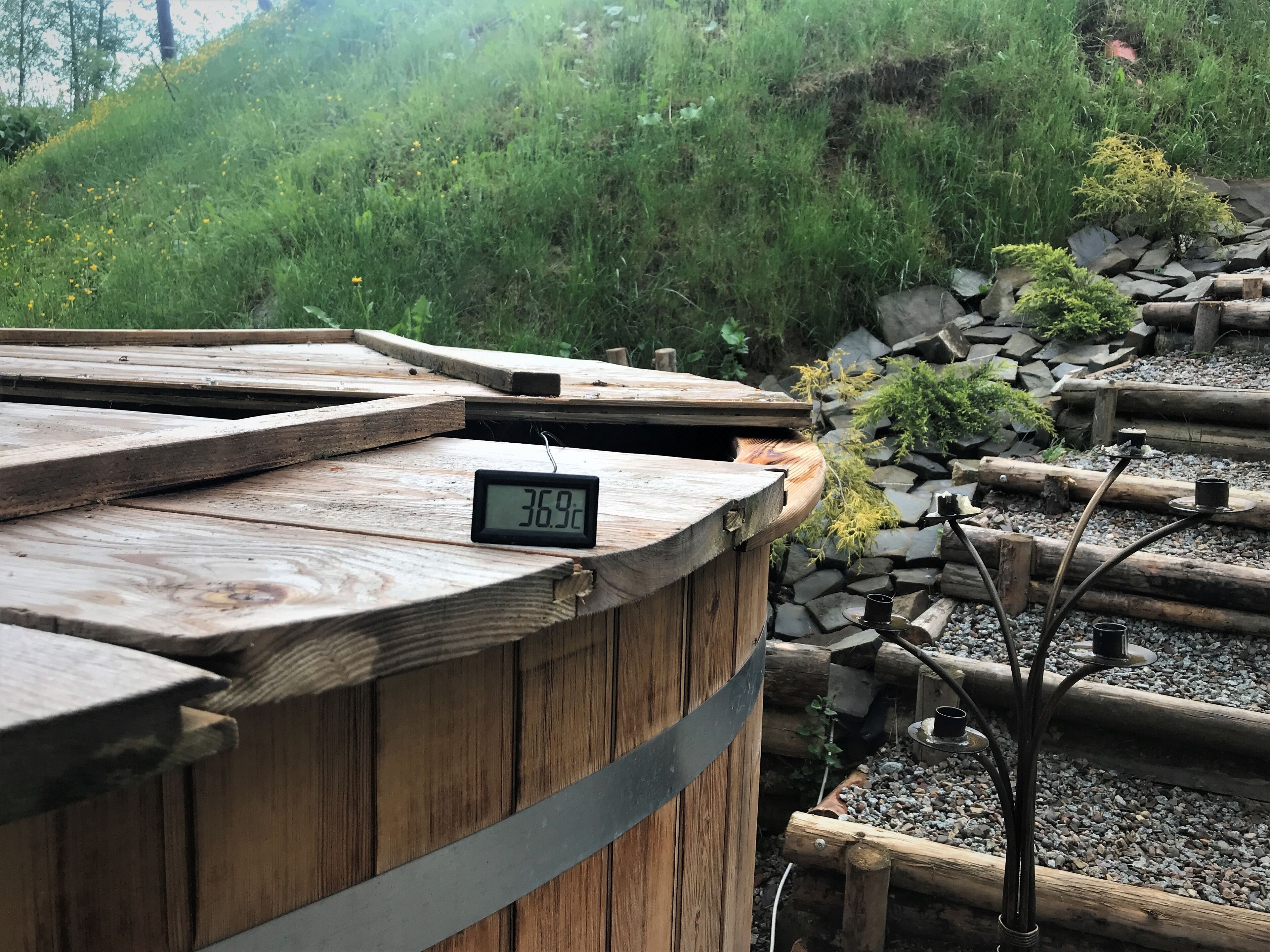 En träkonstruktion med en digital klocka som visar 36,9 °C.