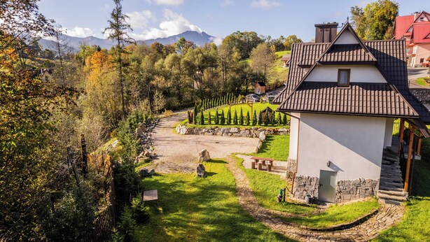 Una casa amb fonaments de pedra, teulada de rajola i un petit porxo.