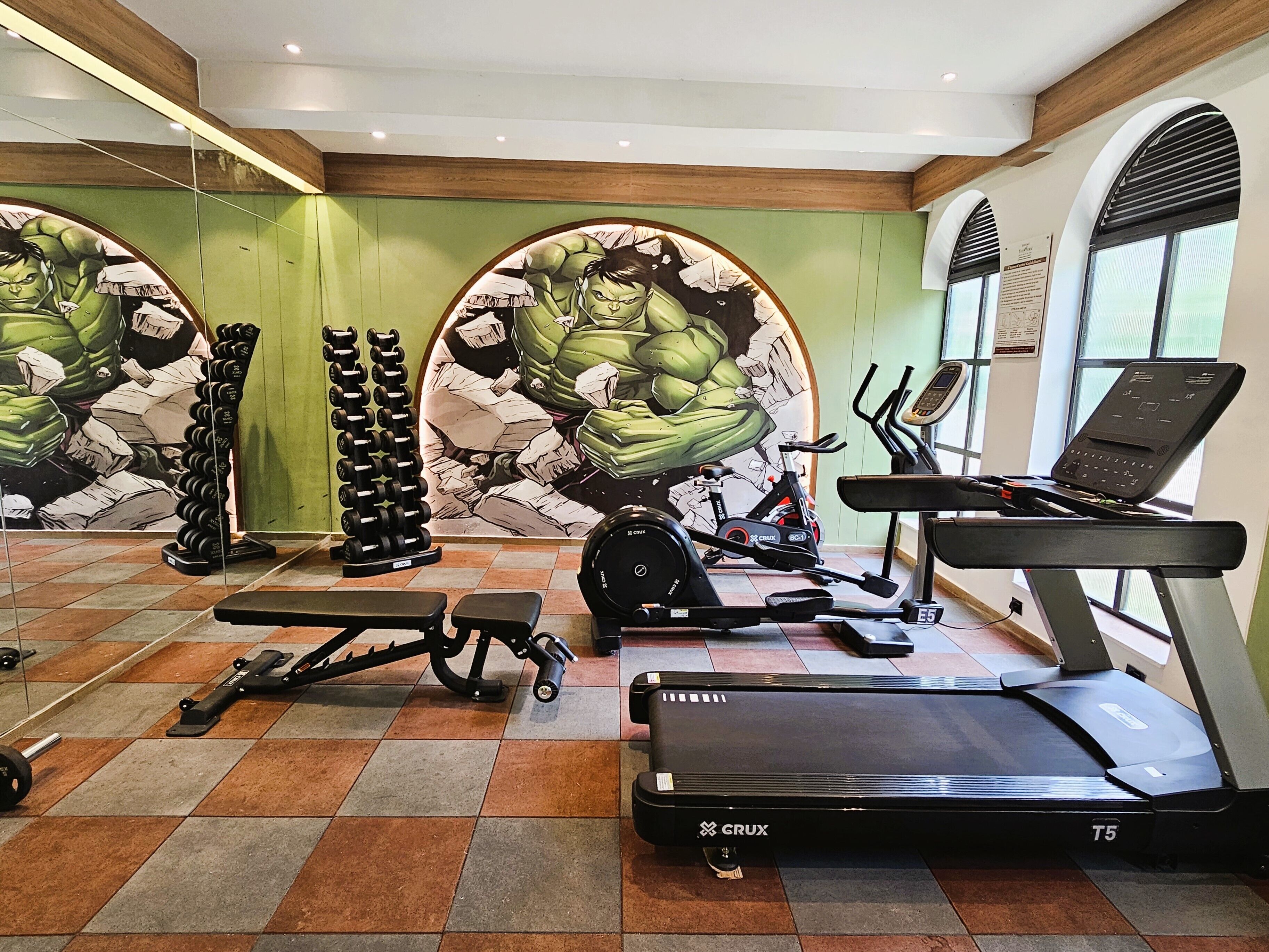 A gym with exercise equipment, including treadmills, stationary bikes, and weight racks.