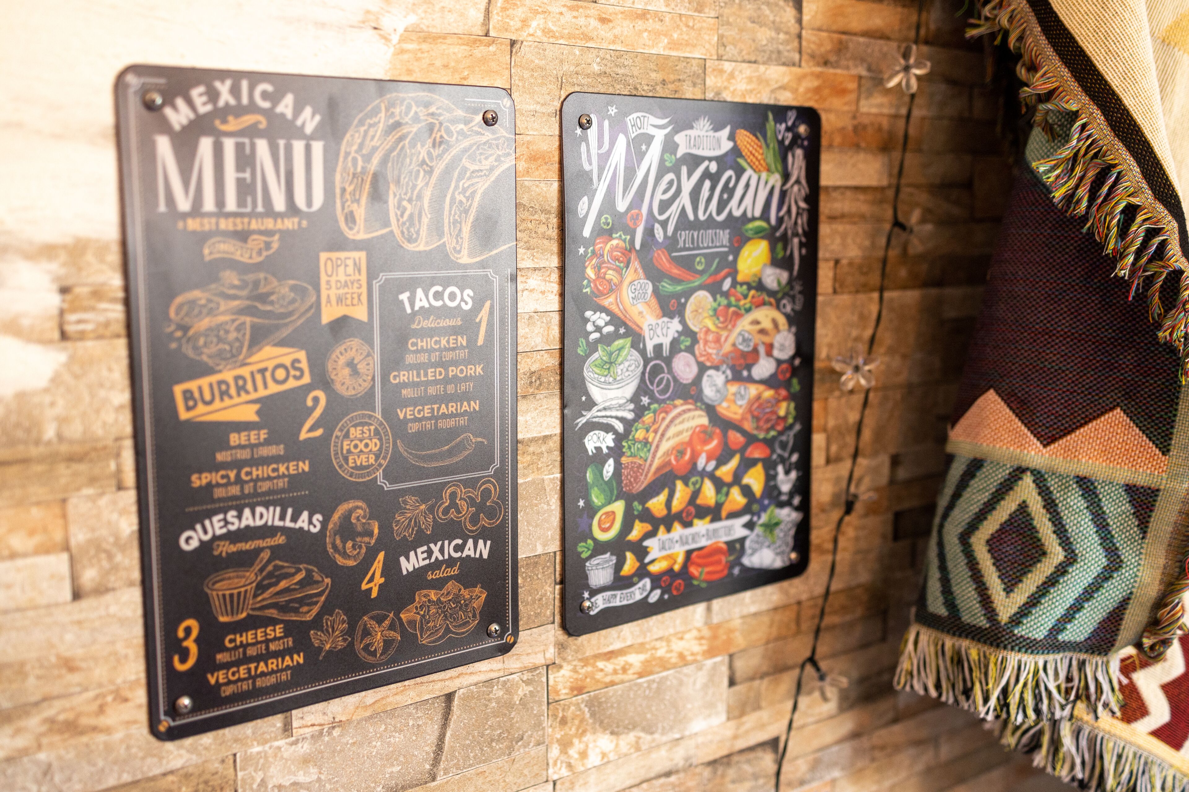 Two Mexican-themed menu boards on a brick wall.