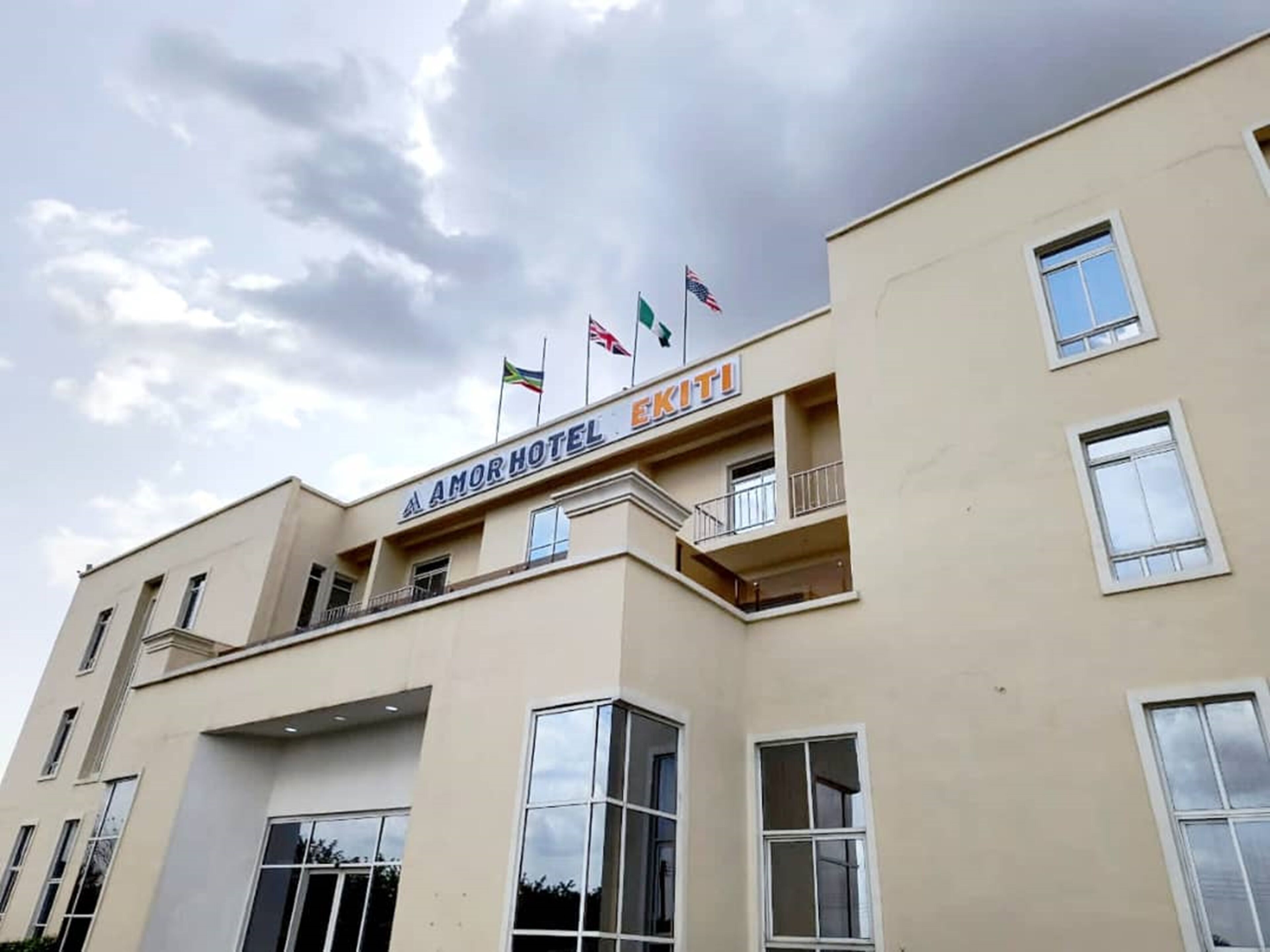 A hotel building with multiple floors, balconies, and flags on the roof.