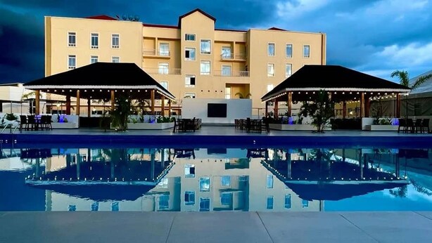 A hotel with a swimming pool, outdoor seating areas, and a large building with multiple balconies. - Amor Hotel Ekiti (Ado Ekiti)