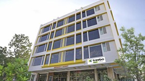 A multi-story building with a modern architectural design, featuring a prominent yellow and white color scheme. - Treebo Royal Cm - City Center (Jaipur)
