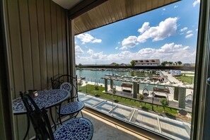 A balcony with a view of a marina and a bridge.