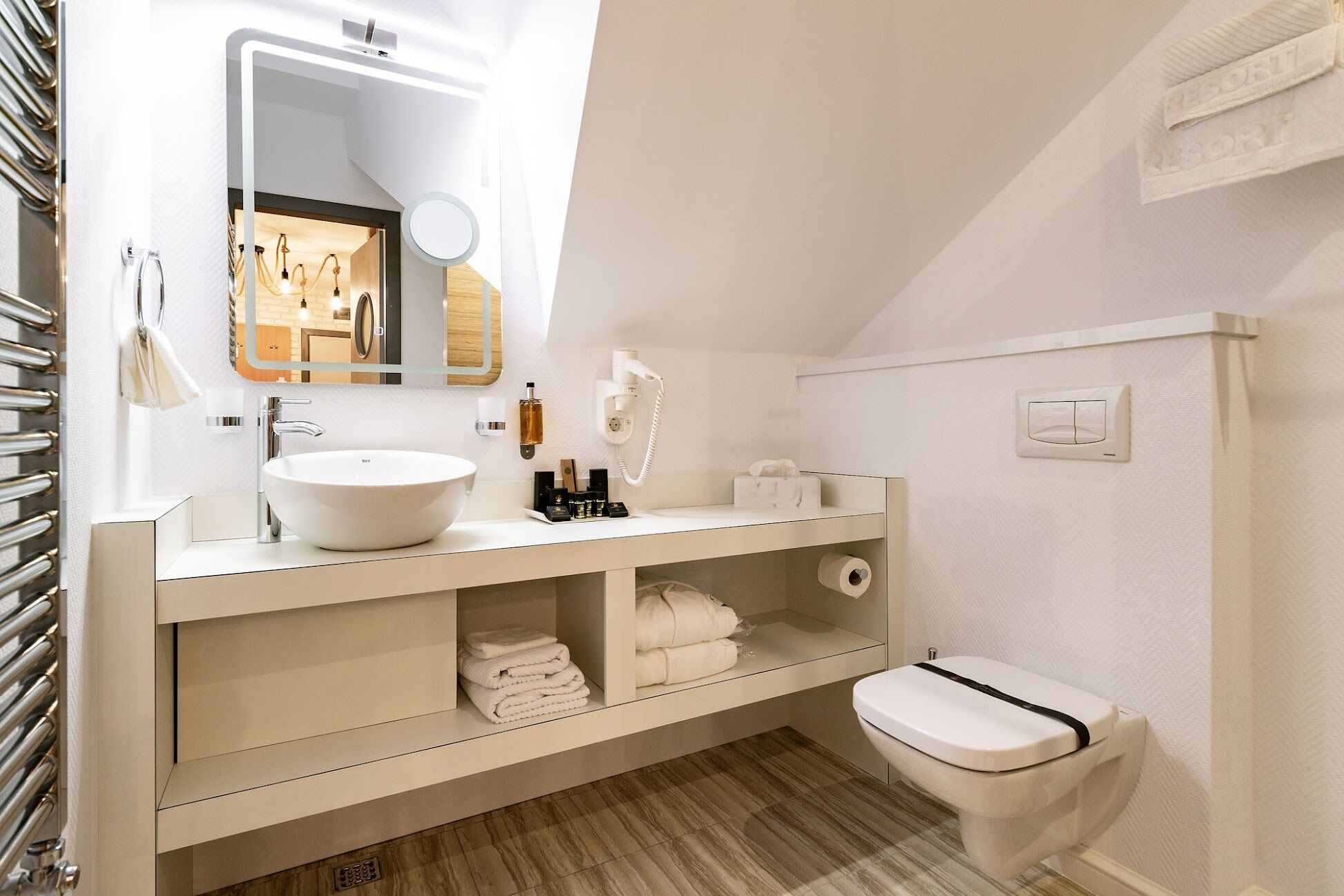 Een moderne badkamer met een wit wastafelmeubel, wastafel en toilet.