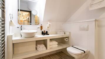 Een moderne badkamer met een wit wastafelmeubel, wastafel en toilet.