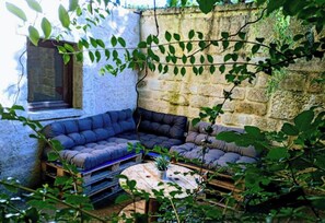 A cozy corner with a cushioned seating area, a small round table, and a window. - 2-room apartment with a courtyard and a romantic terrace. Exceptional wellness area (additional charge), pets allowed (Saint-Cirq)
