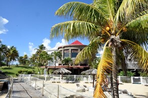 Un resort con piscina, palmeras y un edificio de techo rojo.