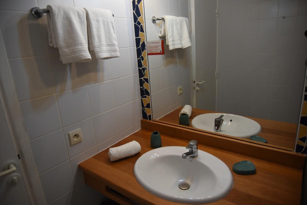 A bathroom with a sink, mirror, and towels.