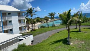 Een resort met een zwembad, palmbomen en uitzicht op de oceaan.