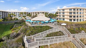 Ein Resort mit mehreren Gebäuden, Außenpools und einem hölzernen Steg, der sie miteinander verbindet.