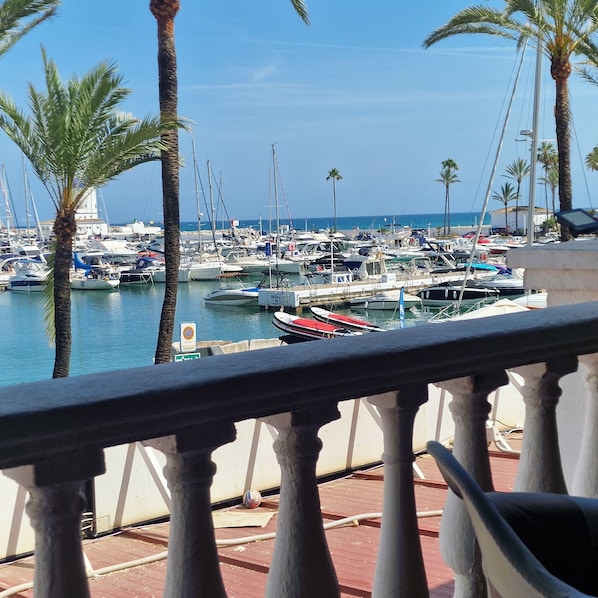 A marina with boats docked, palm trees, and a clear sky. - Stylish 2 bed 2 bath property on Duquesa Fairways , 2 terraces, 2 pools (Manilva)
