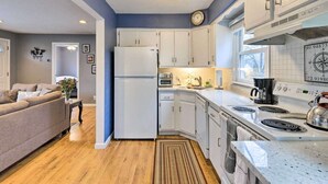 A compact kitchen with white cabinets, a refrigerator, a stove, and a coffee maker. - Homelike, peaceful and centrally- home located in the hamlet of Rocky  Point  NY (Rocky Point)