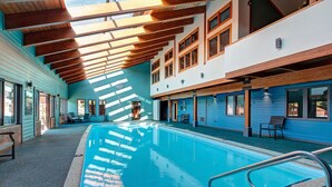 Ein Hallenbad mit Holzbalkendecke und blauen Wänden.