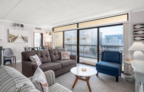 Relax in this stylish living room with a sliding glass door leading to a balcony offering a view of the surrounding area.
