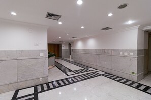 Experience the sleek, contemporary design of our hotel's minimalist corridor, featuring a polished floor and elegant walls.