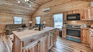 Ein Holzblockbau-Innenraum mit Küche, Essbereich und einer Couch.
